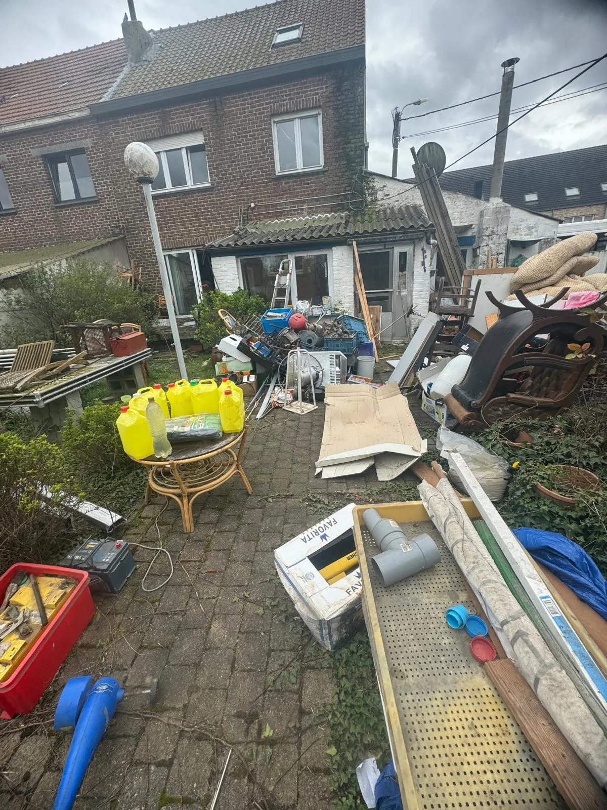 Avant débarras à Lierre — Abords de maison rangés et pelouse dégagée